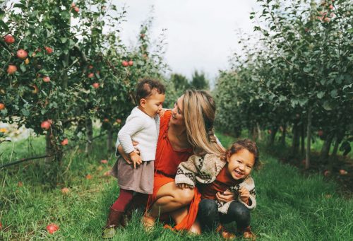 Mom with kids in apple orchard