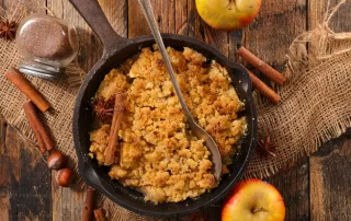 apple bake with oats cinnamon and brown sugar in a cast iron baking dish