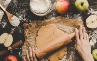 woman rolling out dough for apple pastry bake