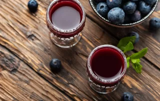 blueberries and blueberry fruit wine in crystal glasses
