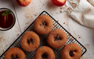 fresh made cinnamon donuts with tea and red apples