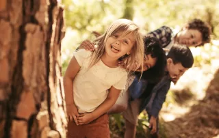 group of silly children playing in a forest